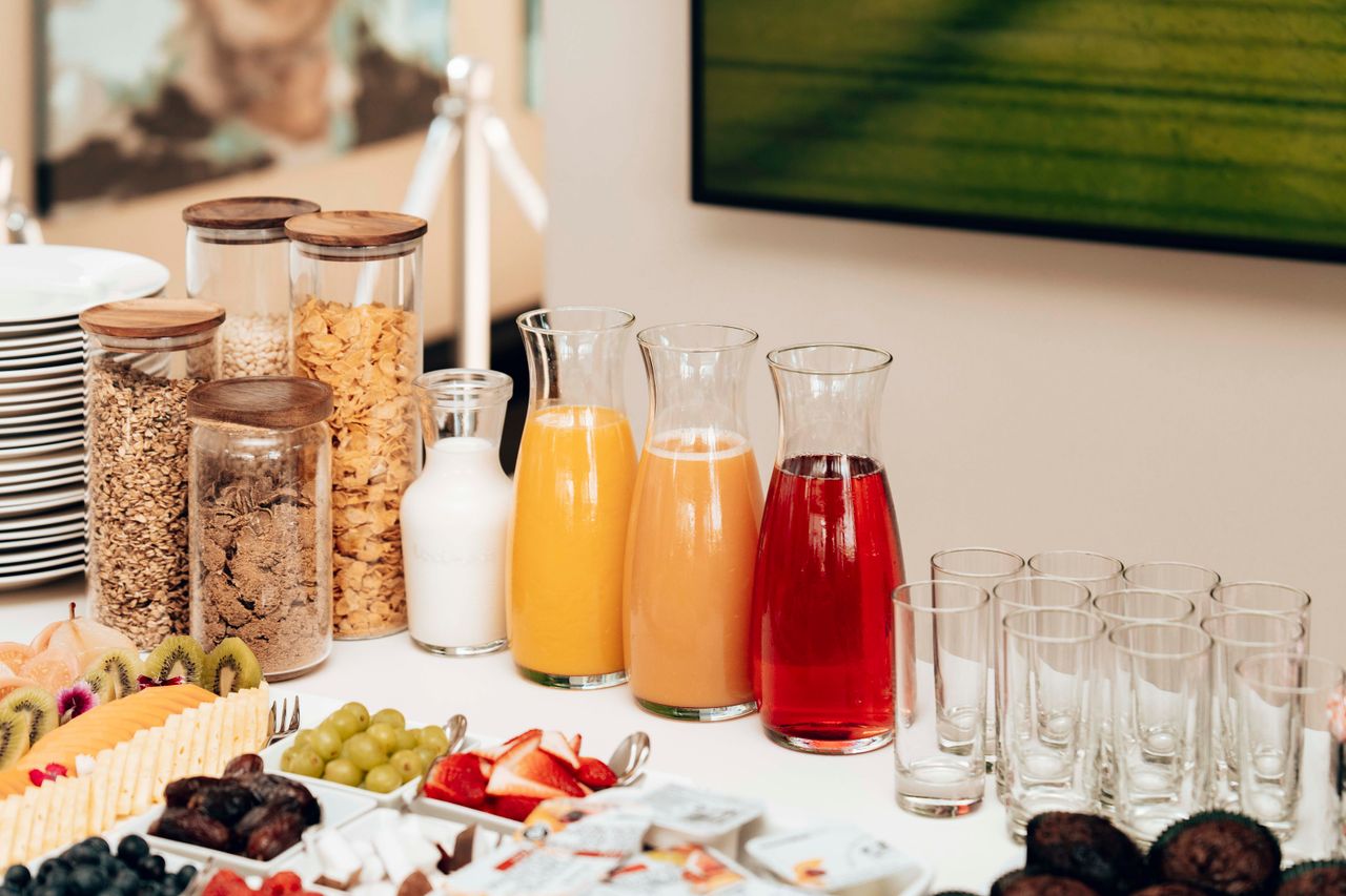 An inviting breakfast buffet featuring juices, cereals, milk, fruits, and cutlery.